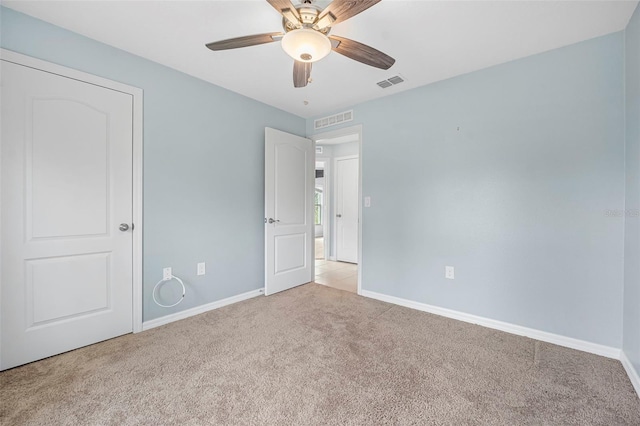 carpeted spare room featuring ceiling fan