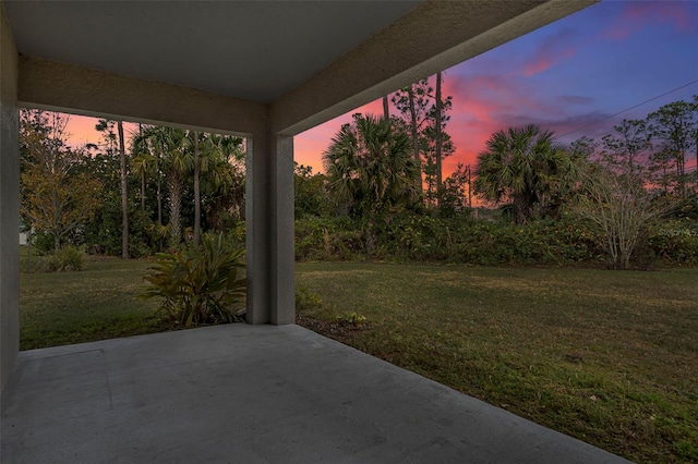 yard at dusk featuring a patio area