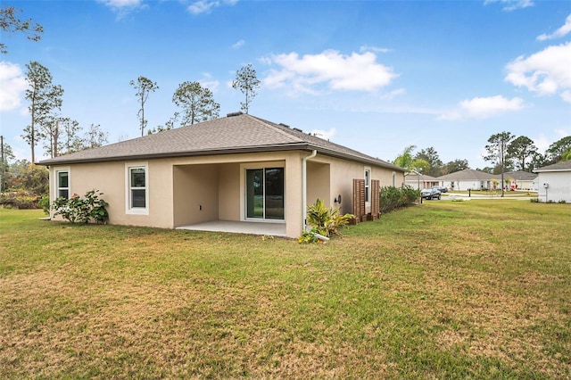 rear view of house featuring a lawn and a patio