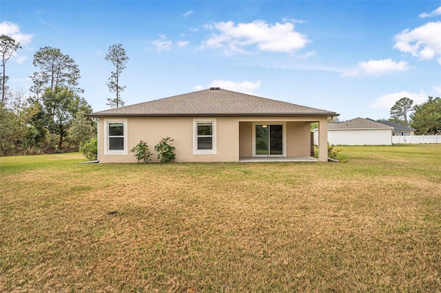 back of property with a lawn and a patio