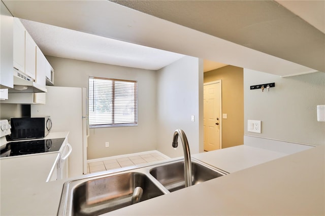 kitchen with range, white cabinetry, and sink