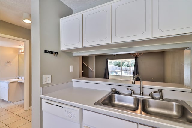 kitchen with white cabinets, light tile patterned floors, white dishwasher, and sink