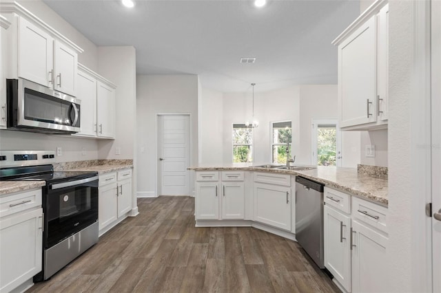 kitchen with pendant lighting, sink, white cabinetry, dark wood-type flooring, and stainless steel appliances