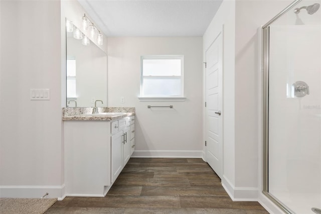 bathroom featuring vanity, wood-type flooring, and a shower with door