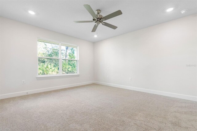 carpeted spare room featuring ceiling fan