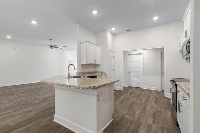 kitchen featuring ceiling fan, electric range, sink, white cabinetry, and dark wood-type flooring