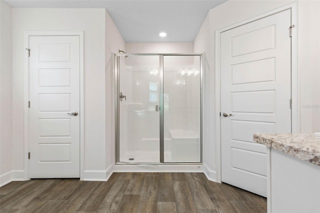 bathroom featuring wood-type flooring and an enclosed shower