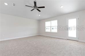 carpeted spare room featuring ceiling fan