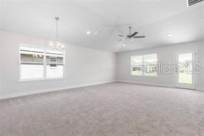 carpeted spare room featuring ceiling fan and vaulted ceiling