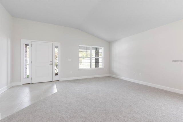 entryway featuring light tile patterned floors and vaulted ceiling