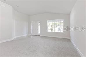 carpeted empty room featuring lofted ceiling