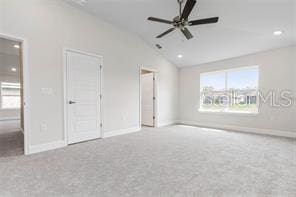 unfurnished bedroom with light colored carpet, vaulted ceiling, and ceiling fan