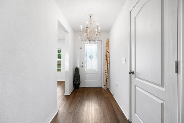 doorway to outside featuring a notable chandelier and dark hardwood / wood-style floors