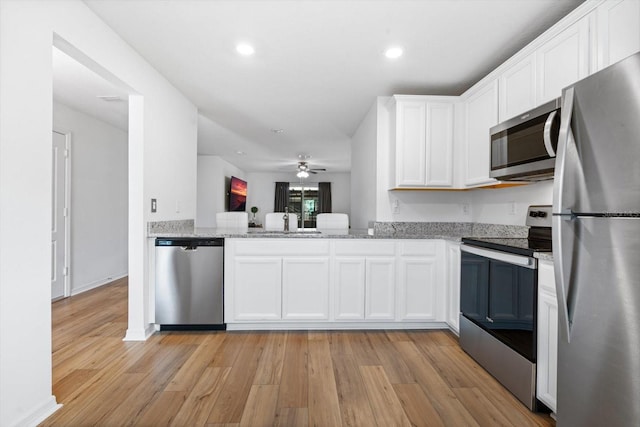 kitchen featuring white cabinets, stainless steel appliances, and light hardwood / wood-style flooring