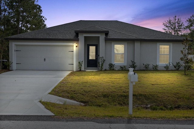 view of front facade with a garage and a lawn