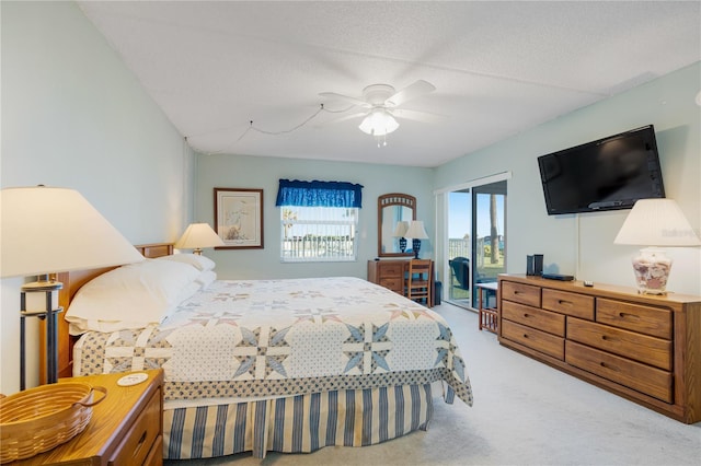 bedroom with access to exterior, a textured ceiling, carpet floors, and ceiling fan