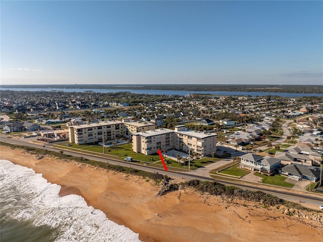 birds eye view of property featuring a water view and a beach view