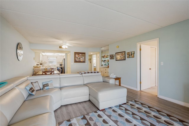 living room with ceiling fan and light hardwood / wood-style flooring