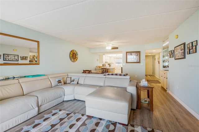 living room featuring ceiling fan and wood-type flooring