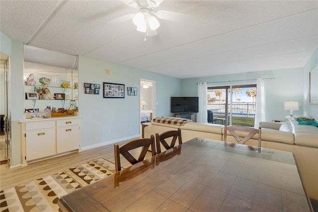 dining area featuring a textured ceiling, light hardwood / wood-style flooring, and ceiling fan