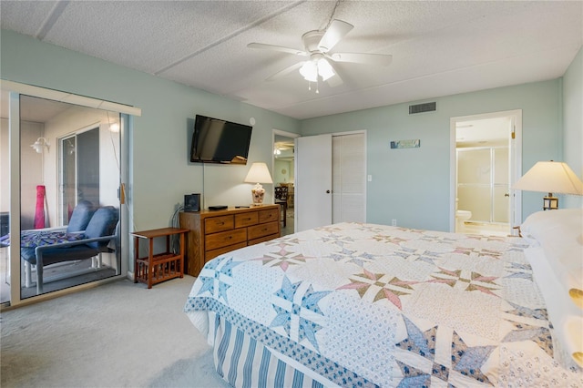 bedroom featuring carpet flooring, ensuite bathroom, a textured ceiling, ceiling fan, and a closet