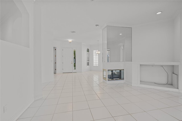 unfurnished living room featuring a multi sided fireplace, light tile patterned floors, and an inviting chandelier