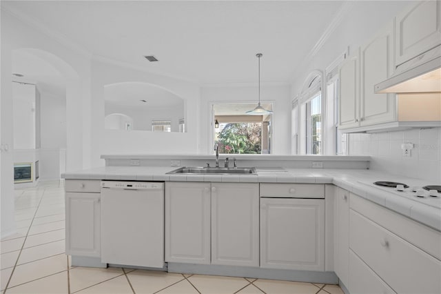 kitchen with sink, crown molding, white dishwasher, tile counters, and white cabinets