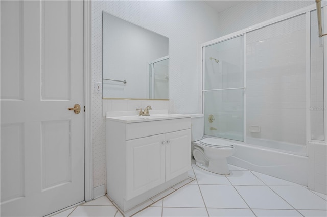 full bathroom with enclosed tub / shower combo, tile patterned floors, toilet, and vanity