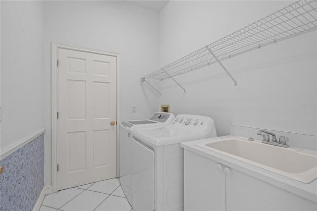 laundry area with separate washer and dryer, sink, and light tile patterned floors