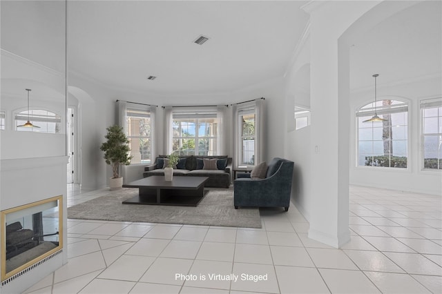 living room with crown molding and light tile patterned flooring