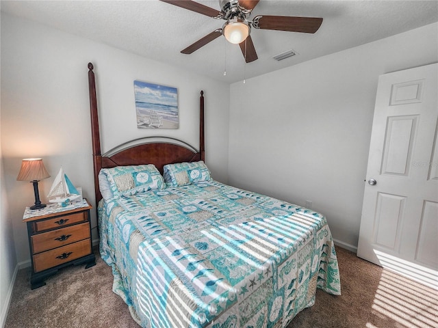 carpeted bedroom featuring a textured ceiling and ceiling fan