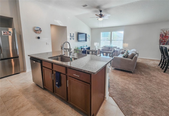 kitchen featuring ceiling fan, sink, stainless steel appliances, an island with sink, and lofted ceiling