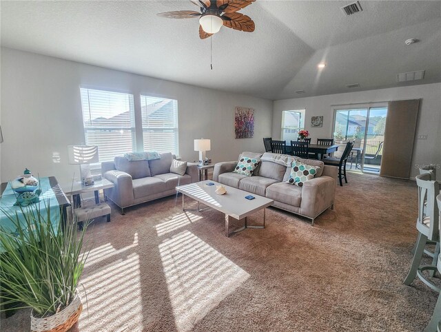 carpeted living room with plenty of natural light, ceiling fan, a textured ceiling, and vaulted ceiling