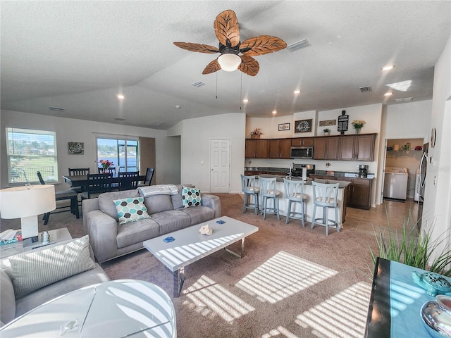 carpeted living room featuring ceiling fan, lofted ceiling, and a textured ceiling