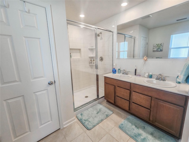 bathroom featuring tile patterned flooring, vanity, and a shower with door