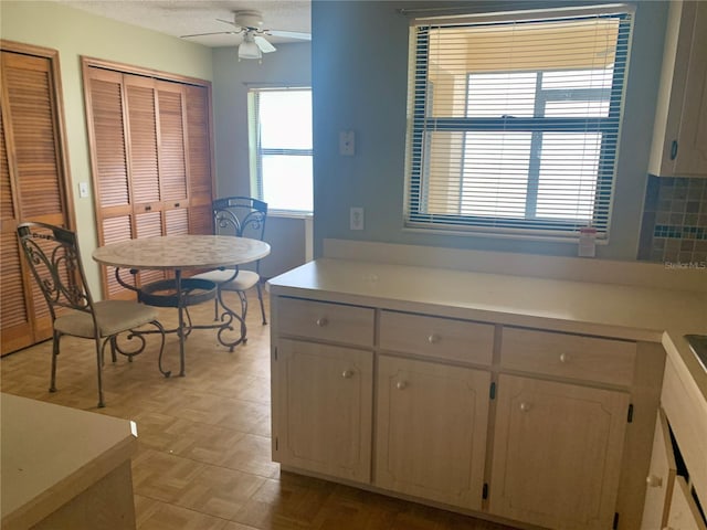 kitchen featuring tasteful backsplash, ceiling fan, and light parquet floors