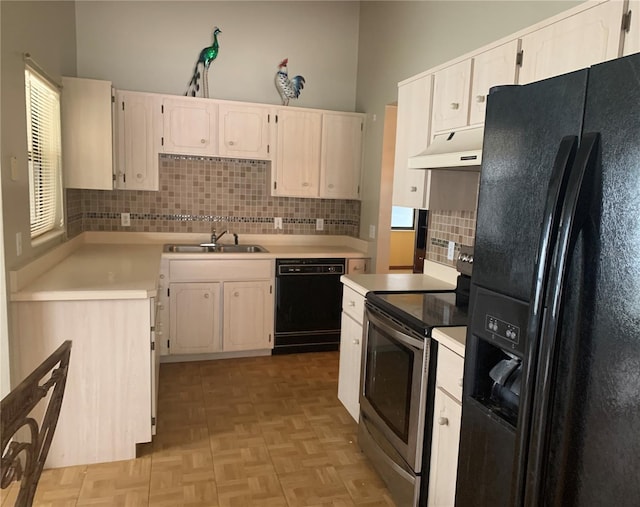 kitchen with light parquet floors, sink, white cabinetry, and black appliances