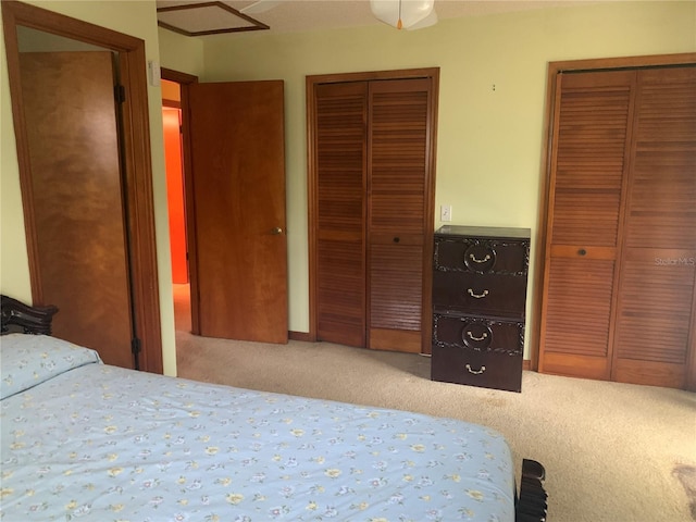 bedroom featuring multiple closets and carpet floors