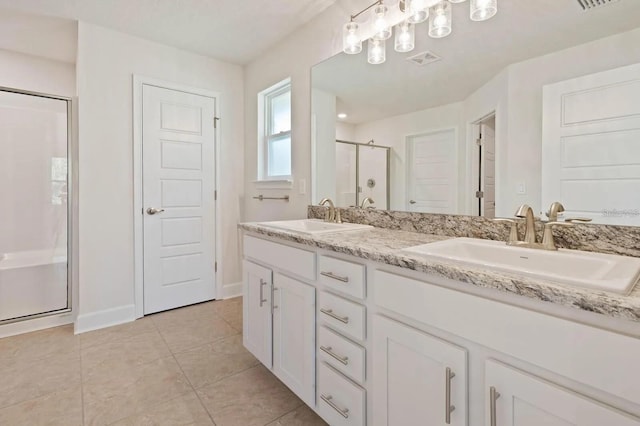 bathroom with tile patterned flooring, vanity, and walk in shower