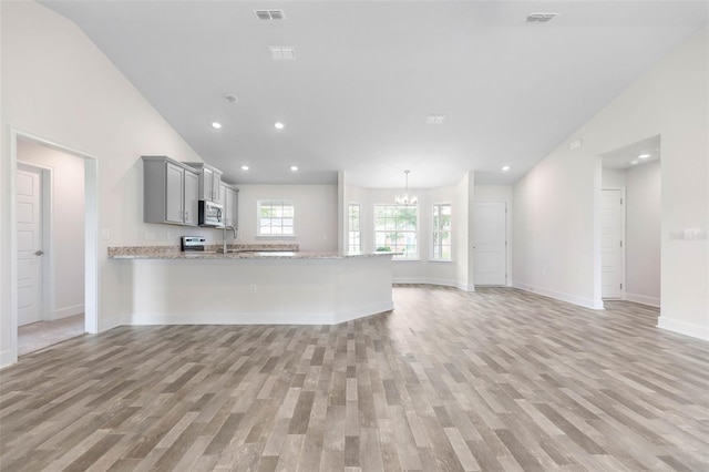 kitchen with gray cabinetry, light hardwood / wood-style floors, and kitchen peninsula