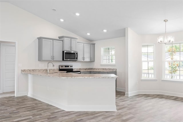 kitchen with stainless steel appliances, light hardwood / wood-style flooring, lofted ceiling, and sink