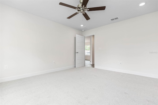 spare room featuring light carpet and ceiling fan