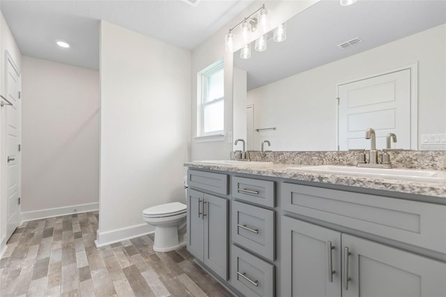 bathroom with hardwood / wood-style floors, vanity, and toilet