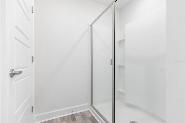 bathroom featuring an enclosed shower and hardwood / wood-style flooring