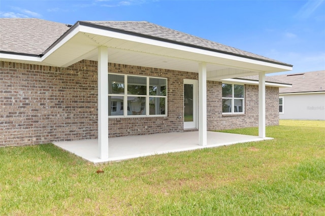 back of property featuring a lawn and a patio