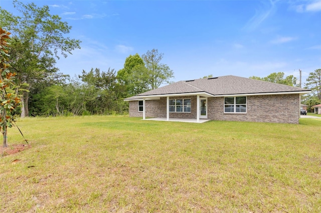 rear view of property with a lawn and a patio area