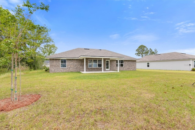 rear view of property featuring a lawn and a patio