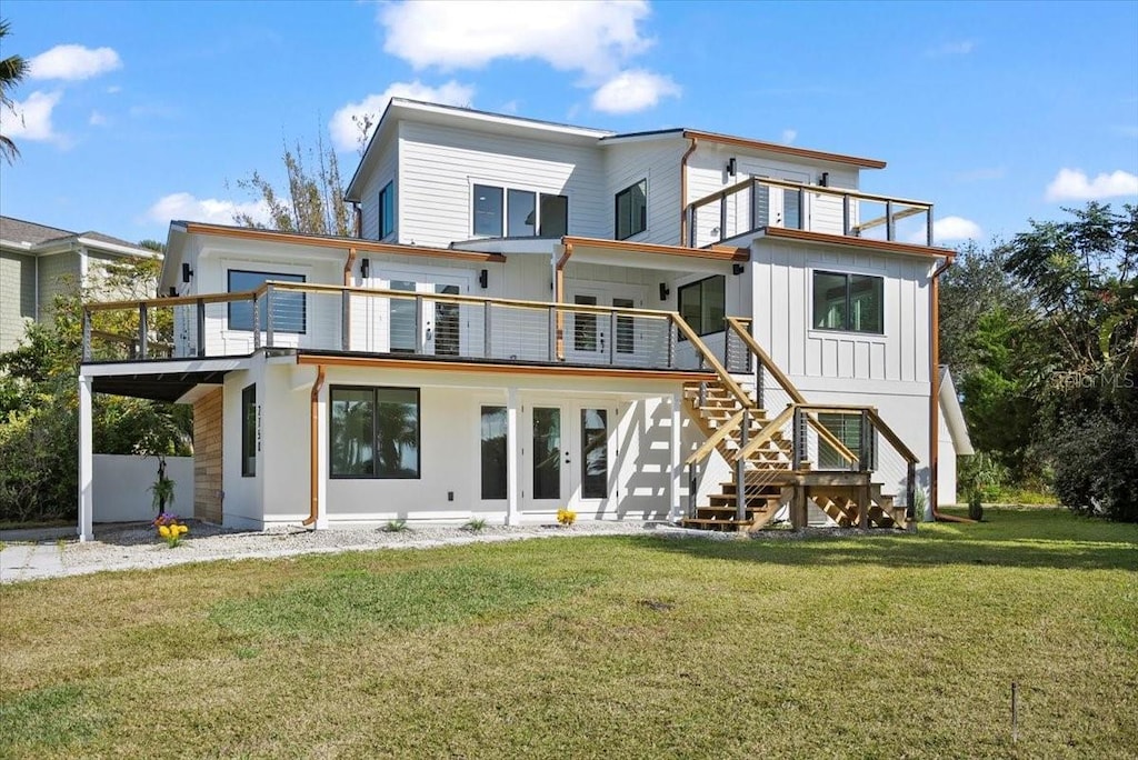 rear view of property featuring a yard and a balcony