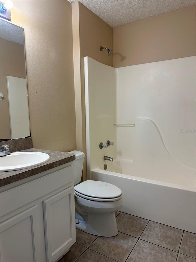 full bathroom featuring vanity, tile patterned flooring, toilet, a textured ceiling, and tub / shower combination