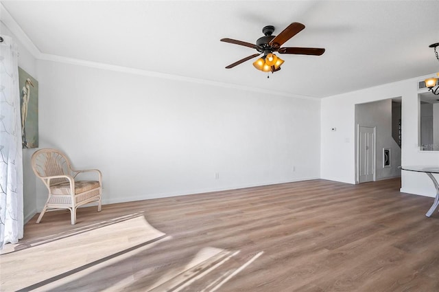 unfurnished living room featuring ornamental molding, ceiling fan with notable chandelier, and hardwood / wood-style flooring